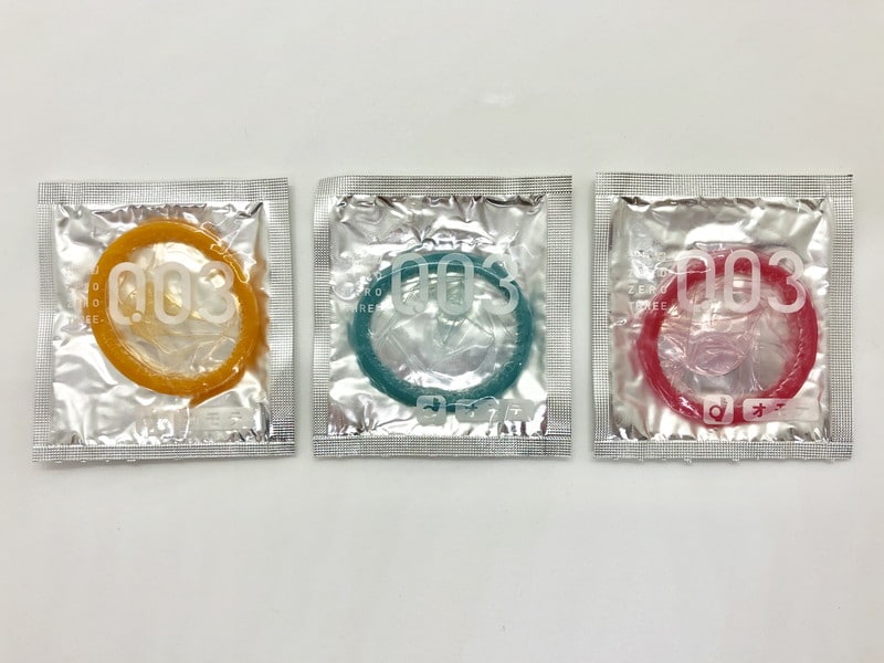 「オカモトゼロゼロスリー 0.03ミリ 3色カラー」のコンドーム袋（表）を3色並べた